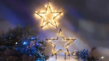 Festliche Szene mit zwei leuchtenden Sternen, ideal als Weihnachtsdekoration für eine warme und einladende Atmosphäre.