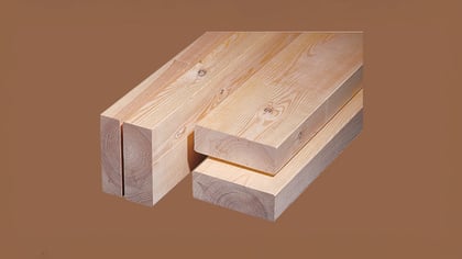 Bauholzstapel: Ein Nahaufnahme von gestapeltem, hellem Bauholz mit sichtbaren Holzmaserungen und Astlöchern. Ideal für Bauprojekte.