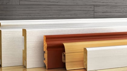 Surtido de zócalos de madera en acabados blanco, marrón y natural, mostrando varios perfiles.