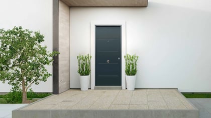 Moderna puerta de entrada gris oscuro en un acceso de casa.