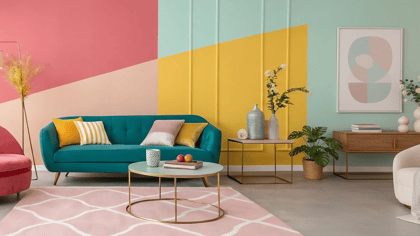 Farbiger Wohnraum mit einem türkisfarbenen Sofa, einem rosa Sessel und einem cremefarbenen Sessel, die eine einladende und moderne Atmosphäre schaffen.
