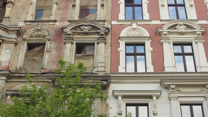 Fassade eines Gebäudes, die den Verfall des linken Teils im Gegensatz zur Renovierung des rechten Teils zeigt.
