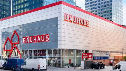 Gran tienda Bauhaus moderna con fachada blanca, acentos rojos y ventanas de cristal, en un entorno urbano.