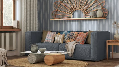 Gemütliches Wohnzimmer mit grauem Sofa, Holzmöbeln und warmen Deko-Akzenten.