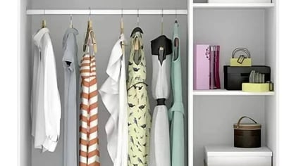 Un armario blanco abierto, con una barra para colgar ropa y estantes con bolsos y cajas de almacenamiento.