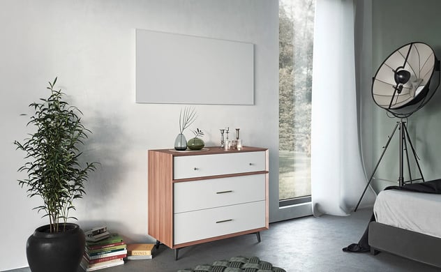 Kommode aus Holz mit weißen Schubladen und Messinggriffen, in einem Raum.