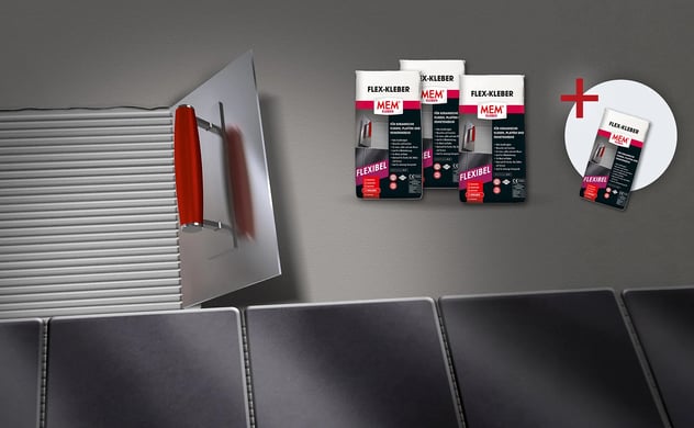 Säcke mit FLEX-KLEBER MEM Fliesenkleber und eine Zahnkelle beim Auftragen des Klebers auf eine Wand über verlegten Fliesen.