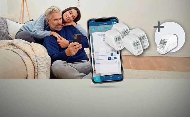 Ein Paar steuert Homematic IP Smart-Heizkörperthermostate (weiß, mit Digitalanzeige 21.0) über eine Smartphone-App für angenehmes Raumklima.