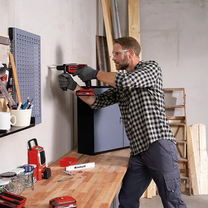 Einhell Power X-Change 18V Akku-Bohrhammer TC-ID 18 Li - Solo - 18 V, Ohne Akku, Schnellspannbohrfutter - Ein Mann bohrt mit einem Einhell Akku-Bohrschrauber ein Loch in eine Wand. Praktisches und effizientes Werkzeug für Heimwerker.