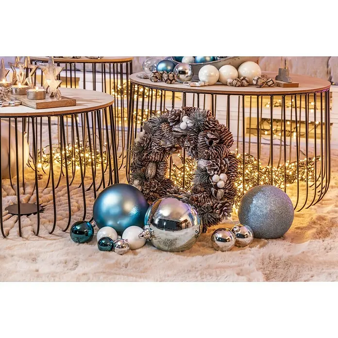 Dekokranz Zapfen, Schneekugeln, Holzsterne - Durchmesser: 33 cm - Festliche Szene mit Tannenzapfenkranz, blauen und silbernen Weihnachtskugeln auf einem flauschigen Teppich, vor Tischen mit Lichtern.