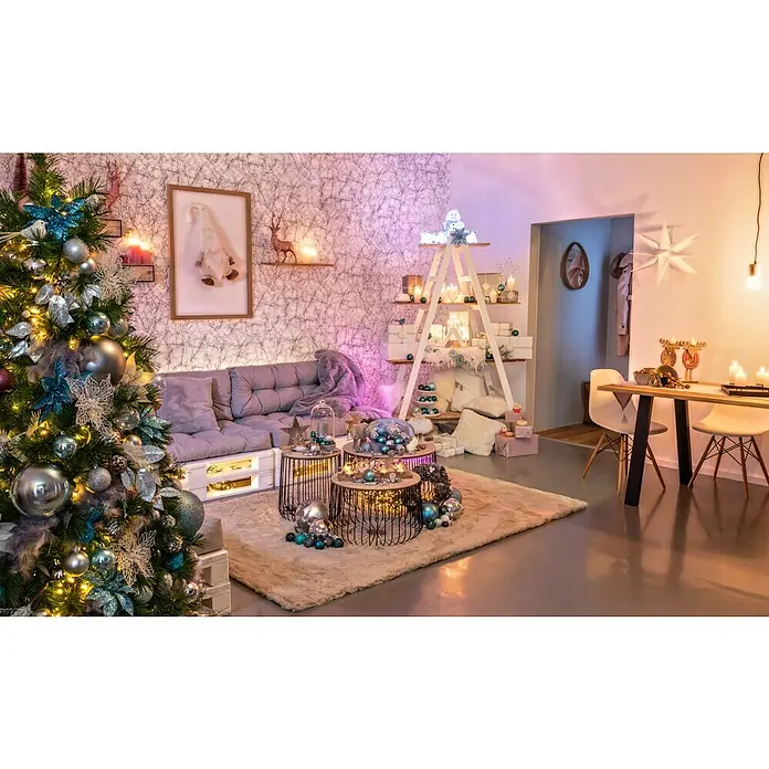 Tween Light Figura LED navideña Muñeco de Nieve - 17 x 16 x 31 cm, Blanco, LED - Decoración festiva de la sala de estar con un árbol de Navidad decorado, un sofá, mesas auxiliares y una estantería temática navideña.