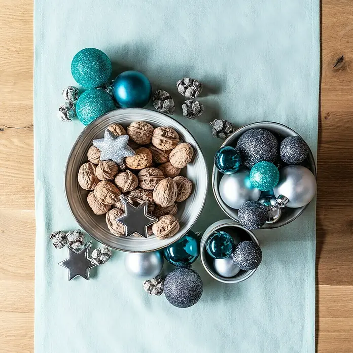Schale Tabo - Ø x H: 14 x 6,5 cm, Grau - Weihnachtliche Tischdekoration mit Walnüssen, Sternen und blauen Kugeln in Schalen auf einem hellblauen Tischläufer.