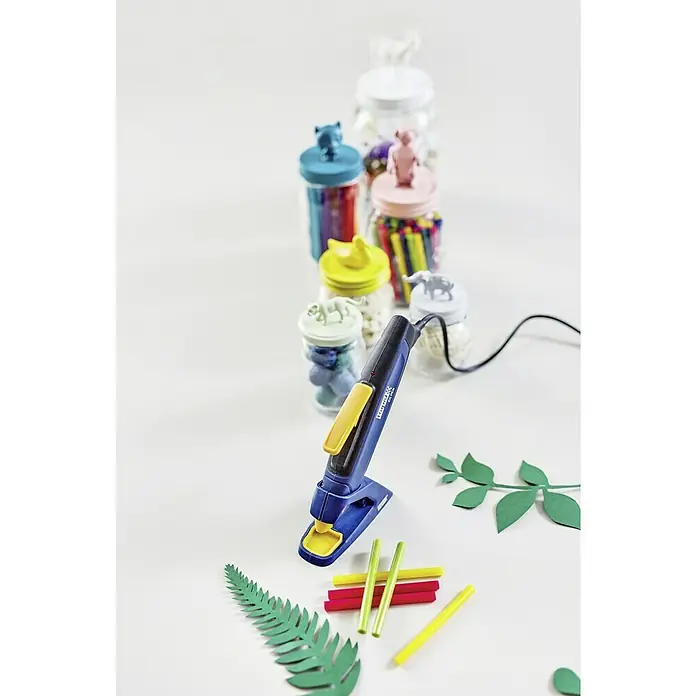 Rapid Heißklebepistole EG - Blau, Gelb, Durchmesser Klebepatrone: 7 mm - Nahaufnahme einer blauen Klebepistole mit gelben Akzenten, umgeben von bunten Bastelmaterialien und Gläsern.