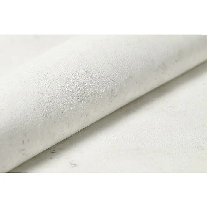 Rasch Vliestapete Beton - Weiß, Betonoptik, 10,05 x 0,53 m - Nahaufnahme einer Rolle strukturierten, cremefarbenen Leders, die die feine Textur und Qualität des Materials hervorhebt.
