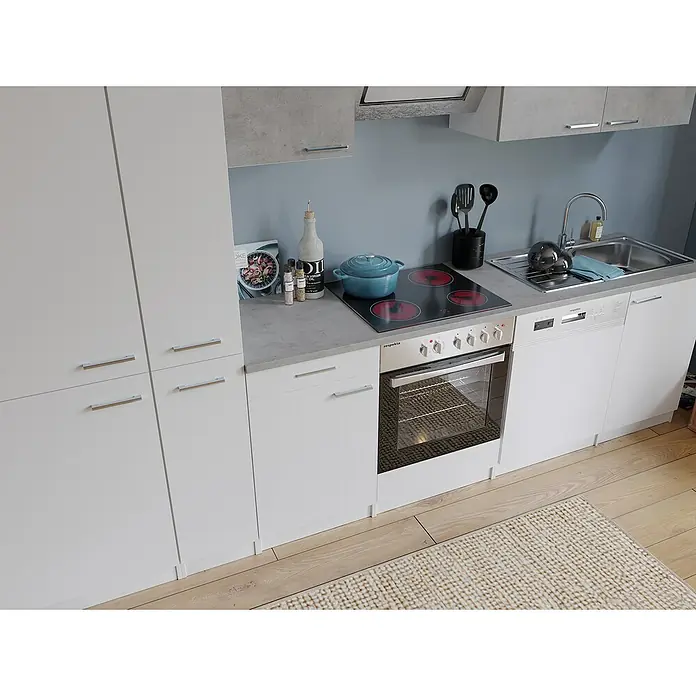 Respekta Küchenzeile Malia Typ 1 - Breite: 310 cm, Weiß/Beton, Mit Elektrogeräten - Eine moderne Küche mit weißen Schränken, einer grauen Arbeitsplatte, einem Kochfeld und einem Backofen. Die Küche ist hell und freundlich gestaltet.