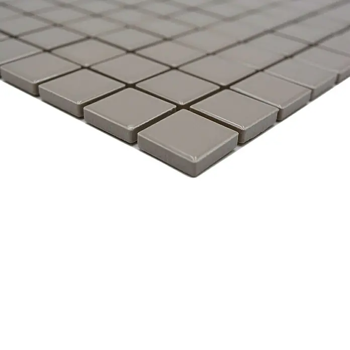 Mosaikfliese Quadrat Uni CG 184 - 29,8 x 29,8 cm, Beige/Braun, Glänzend - Nahaufnahme einer Anordnung quadratischer, grauer Keramikfliesen, die ein modernes und minimalistisches Design auf einer Oberfläche zeigt.