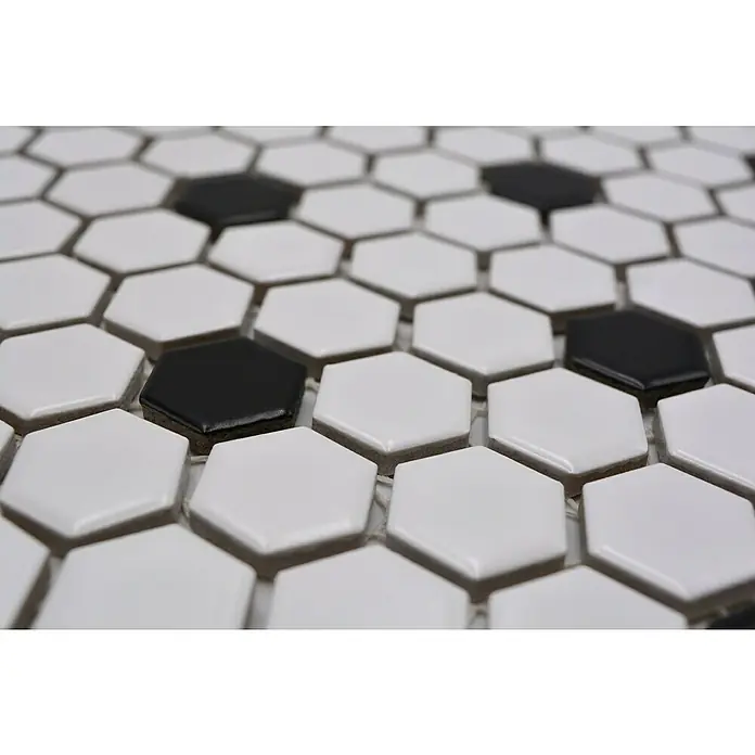 Mosaikfliese Hexagon Mix HX 040 - 26 x 30 cm, Weiß/Schwarz, Matt - Nahaufnahme von weißen und schwarzen sechseckigen Fliesen, die ein geometrisches Muster bilden und eine elegante und moderne Oberfläche schaffen.