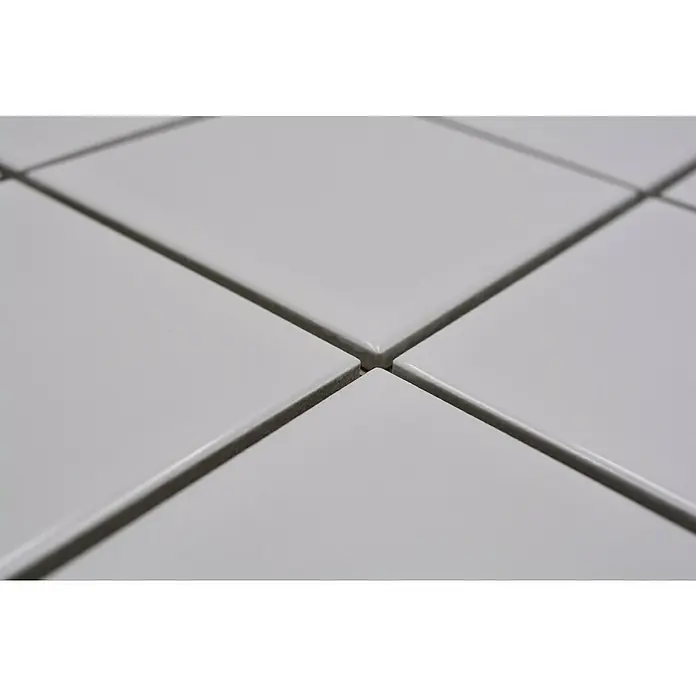 Mosaikfliese Quadrat Uni CQ 100 - 29,8 x 29,8 cm, Weiß, Glänzend - Nahaufnahme von glatten, quadratischen, weißen Fliesen, die mit dunklem Fugenmörtel verlegt sind und ein sauberes, modernes Muster erzeugen.