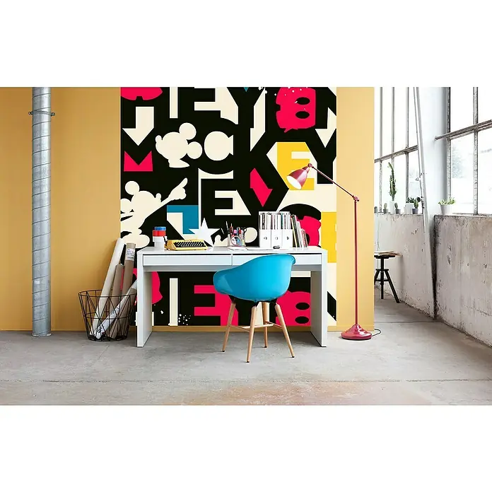 Komar Fototapete Mickey Mixup - B x H: 250 x 280 cm, Vlies - Der moderne Arbeitsbereich mit einem weißen Schreibtisch, einem blauen Stuhl und einer roten Stehlampe vor einer bunten Wand.