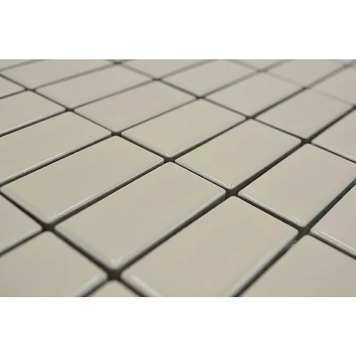 Mosaikfliese Stäbchen Uni ST 400 - 29,8 x 29,8 cm, Beige, Glänzend - Nahaufnahme eines Musters aus rechteckigen, cremefarbenen Keramikfliesen mit glänzender Oberfläche und dunklen Fugenlinien.