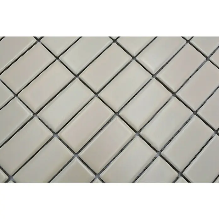 Mosaikfliese Stäbchen Uni ST 40529,8 x 29,8 cm, Beige, Matt - Nahaufnahme von cremefarbenen rechteckigen Mosaikfliesen in einem diagonalen Fischgrätenmuster, ideal für Badezimmer- oder Küchenrückwände.
