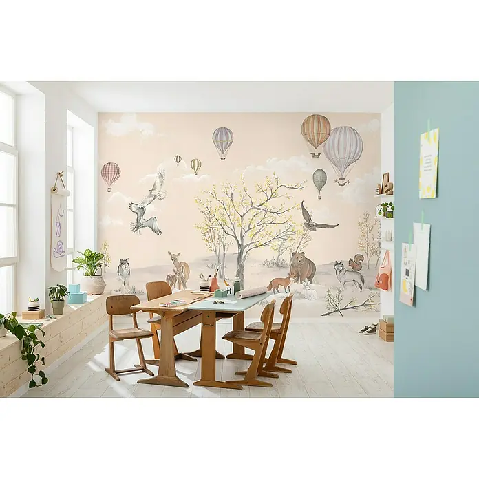 Komar Fototapete Forest Expedition - B x H: 450 x 280 cm, Vlies - Kinderzimmer mit großem Holztisch und Stühlen vor einer Wandtapete mit Waldmotiven und Heißluftballons.