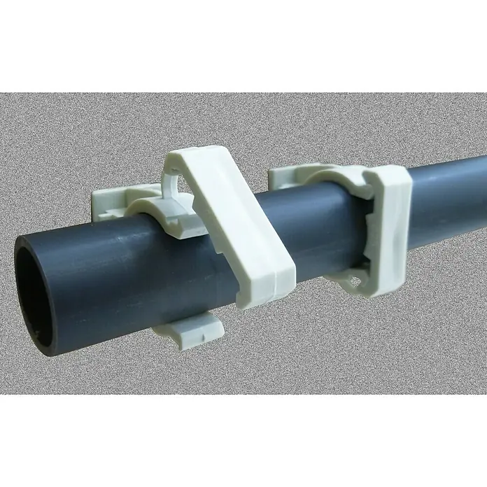 Abrazadera a presión PVC - Diámetro: 20 mm, PVC, 5 ud. - La imagen muestra un tubo de PVC gris fijado a una pared gris con tres abrazaderas de clip blancas.