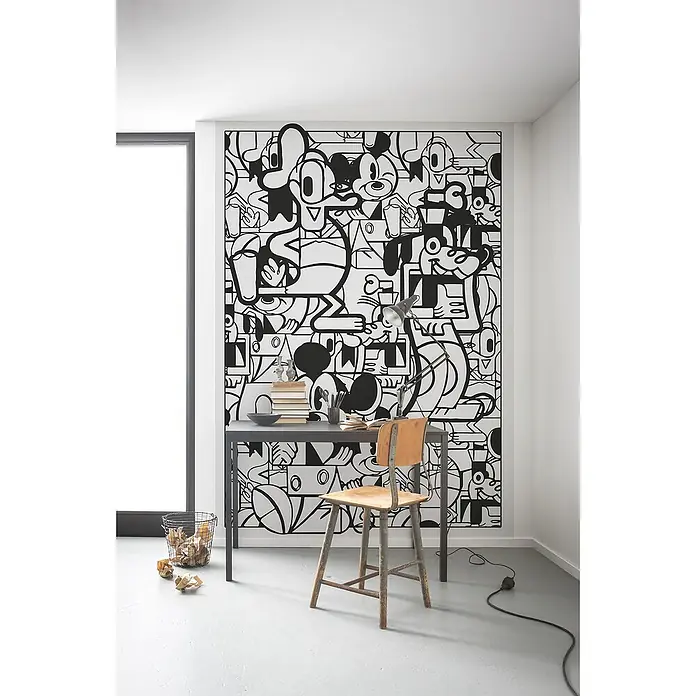 Komar Fototapete Mickey Constructive - B x H: 200 x 280 cm, Vlies - Der Schreibtisch mit Stuhl und der Papierkorb schaffen eine minimalistische und verspielte Arbeitsumgebung vor einer Cartoon-Wand.