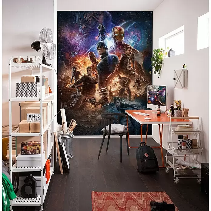 Komar Fototapete Avengers Battle - B x H: 200 x 280 cm, Vlies - Ein modernes Zimmer mit einem großen, lebendigen Avengers-Wandbild, ergänzt durch ein weißes Regal, einen orangefarbenen Schreibtisch mit Computer und einen schwarzen Stuhl.