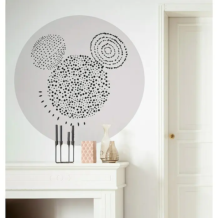 Komar Dots Fototapete rund Mickey Stipple Art128 cm, Selbstklebend - Dekoratives Wandbild mit einem stilisierten Mickey Mouse Motiv über einem weißen Kaminsims mit Vasen und Kerzenhaltern.