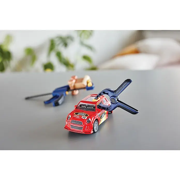 Rapid Zwingen-Set - 5 Stk. - Nahaufnahme eines roten Spielzeugautos, das mit einer blauen Klemme gehalten wird, was die Präzision der Reparatur oder des Umbaus des Autos hervorhebt.