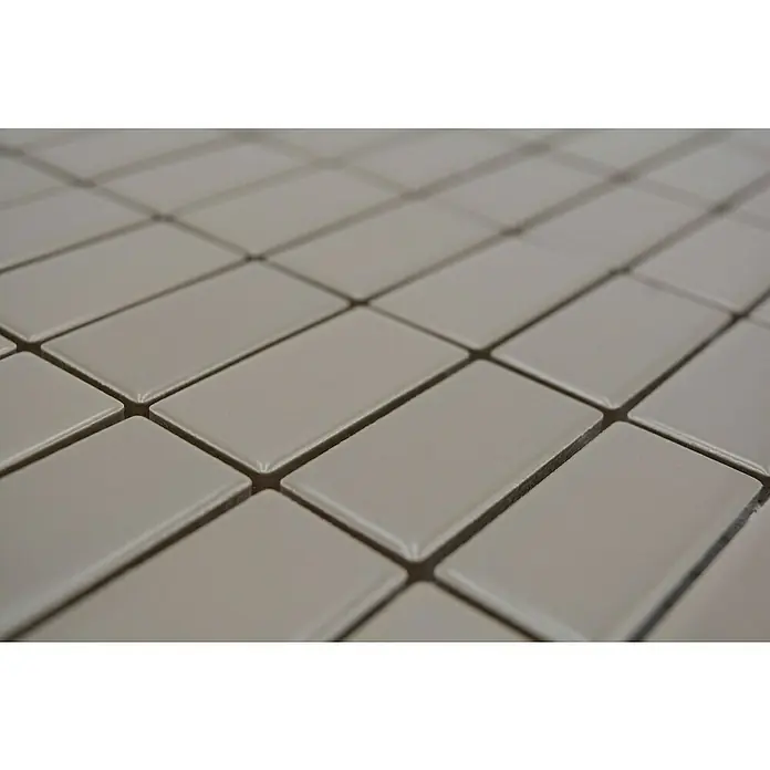 Mosaikfliese Stäbchen Uni ST 415 - 29,8 x 29,8 cm, Beige/Braun, Matt - Nahaufnahme von hellgrauen, rechteckigen Fliesen mit glänzender Oberfläche und subtilen Schatten, die ein elegantes Muster erzeugen.
