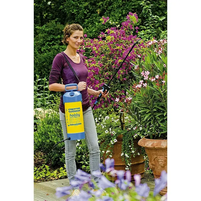 Gloria Drucksprühgerät Hobby Exklusiv mit Teleskopsprührohr - 5 l - Frau sprüht Pflanzen mit GLORIA hobby Exclusiv Drucksprüher im Garten, für Pflanzenpflege und Schädlingsbekämpfung.