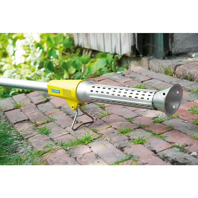 Gloria Unkrautvernichter Thermoflamm bio Electro - 2.000 W, Flammtemperatur: 650 °C - Nahaufnahme eines Gloria Thermofix Weed Brush Weed Burner, der auf einem Ziegelsteinpflaster mit Gras steht.