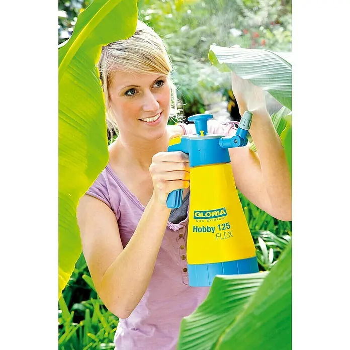 Gloria Drucksprühgerät Hobby 125 FLEX - 1,25 l, 360 ° Funktion - Eine junge Frau benutzt einen Gloria Hobby 125 FLEX Drucksprüher im Garten, um Pflanzen zu bewässern.
