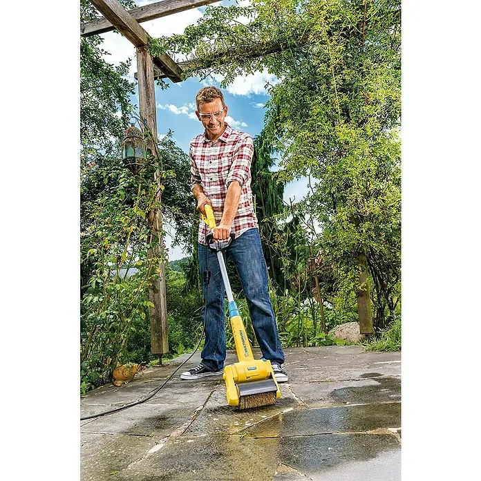 Gloria Bürstenwalze Steinbürste PRO - Geeignet für: Beseitigung von Schmutz, Passend für: Gloria Bodenreinigungsbürsten MultiBrush speedcontrol/li-on, PowerBrush speedcontrol - Mann reinigt Terrasse mit gelber Gloria MultiBrush-Bürste. Das Gerät entfernt effektiv Schmutz und Moos von Steinplatten.