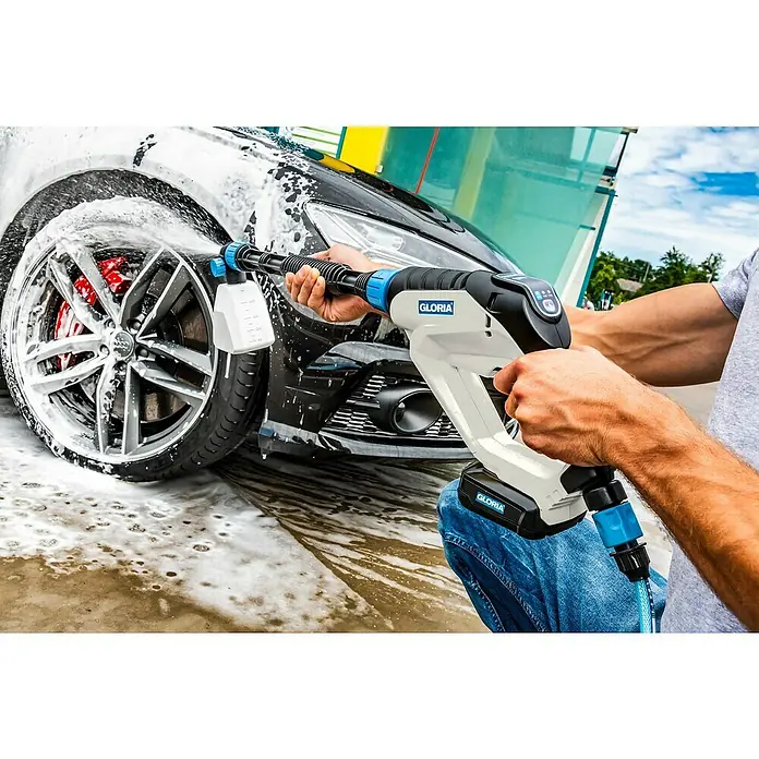 Gloria Power for All 18V Druckreiniger MultiJet - 18 V, Li-Ionen, 1 Akku, Max. Druck: 24,9 bar - Ein Mann wäscht ein Auto mit einem kabellosen Gloria Hochdruckreiniger mit Schaumsprüher, der auf Reifen und Karosserie sprüht.