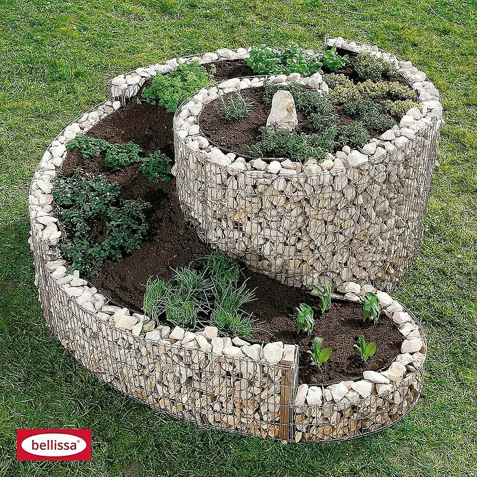 Bellissa Gabionen-Kräuterspirale - 150 x 200 x 80 cm, Stahl, Fassungsvermögen Erde: 1.350 kg - Das Bild zeigt ein spiralförmiges Kräuterbeet aus Steinen und Draht, bepflanzt mit verschiedenen Kräutern auf Rasen.
