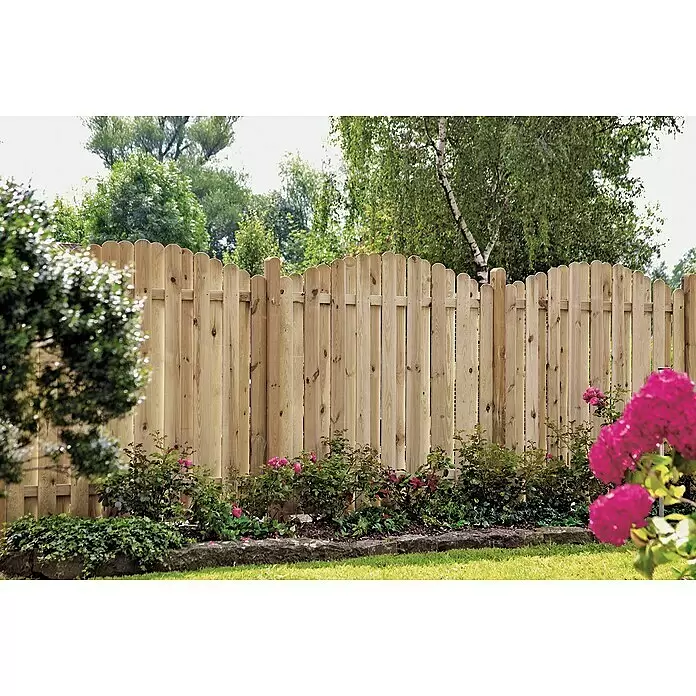 T & J Sichtschutzelement Lieke Bogen - B x H: 180 x 180 cm, Mit Bogen, Braun - Heller Holzzaun mit abgerundeten Latten in einem Garten, umgeben von Pflanzen und Bäumen.