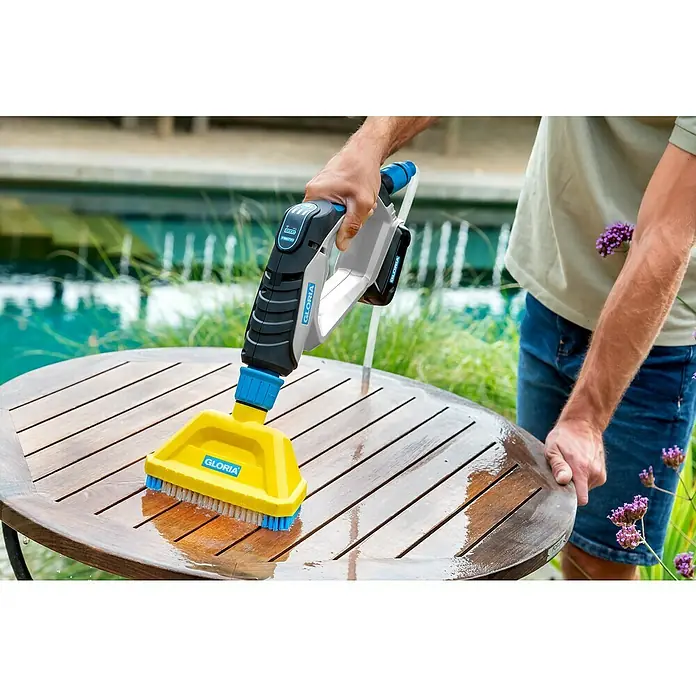Gloria MultiJet Bürsten-Set - Passend für: Gloria Sprühpistole Multijet - Der Gloria MultiBrush Akku-Reiniger im Einsatz, perfekt für die Reinigung von Holzoberflächen wie Tische im Außenbereich.