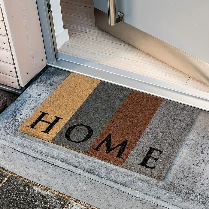Astra Coco Fußmatte Style - 40 x 60 cm, Bunt, Material Nutzschicht: 100 % Kokos, Home, Kokos - Ein bunter Fußabtreter mit der Aufschrift "HOME" liegt vor einer offenen Tür und heißt Besucher willkommen.