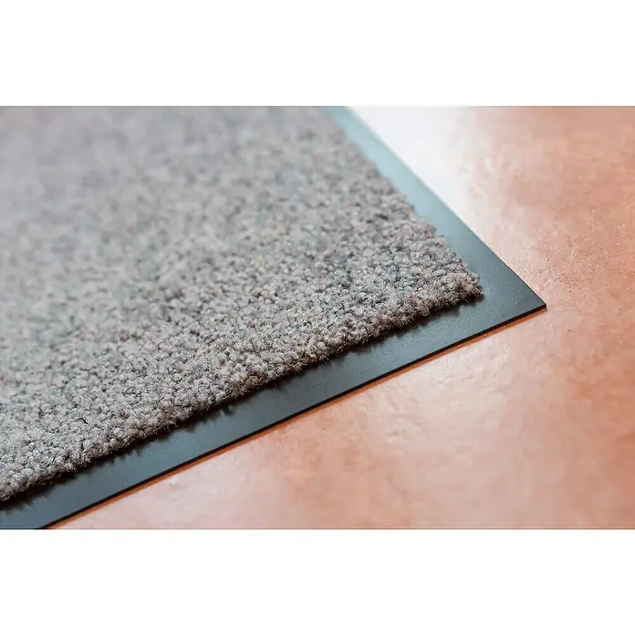 Astra Schmutzfangmatte Proper Tex - Grau, 60 x 180 cm, Material Nutzschicht: 100 % Polyamid - Nahaufnahme einer Fußmatte mit grauer Stoffoberfläche und schwarzem Rand auf einem glatten Boden.