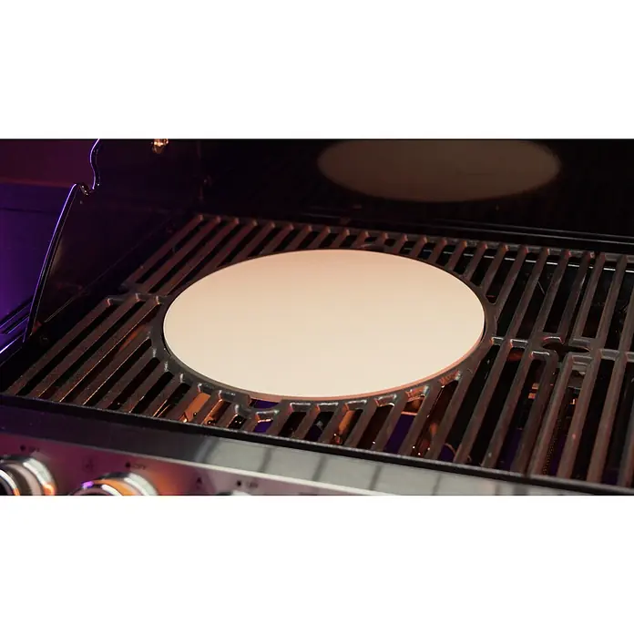 Kingstone KMS Pizzastein - Durchmesser: 30 cm - Nahaufnahme eines Pizzaofens mit einem runden Pizzastein auf dem Grillrost, bereit zum Backen köstlicher Pizzen im Freien.