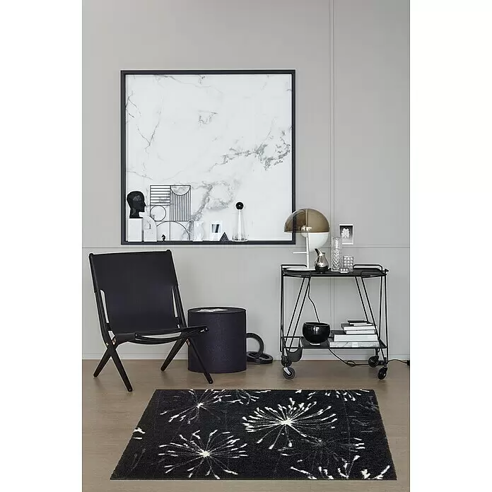 SCHÖNER WOHNEN-Kollektion Fußmatte Pusteblume - Anthrazit/Mint, 100 x 67 cm - Schwarzer Teppich mit weißen Löwenzahnmustern auf einem Holzfußboden in modernem Ambiente.
