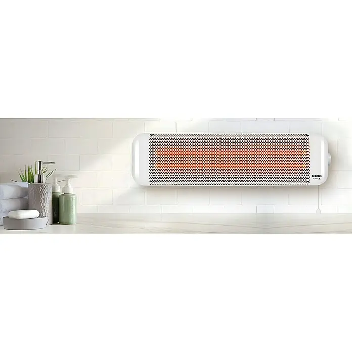 Taurus Estufa de cuarzo Bagno 2Q - 1.200 W, 9,6 x 61 x 16 cm, Blanco - Un calefactor Taurus blanco está montado en una pared de baño sobre un tocador con toallas, jabón, plantas y dispensadores de jabón.