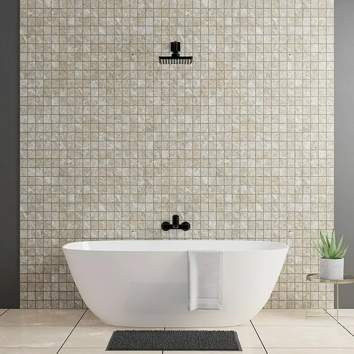 Atlas Concorde Solution Regent Mosaikfliese Ivory - 30 x 30 cm, Stärke: 8 mm, Beige/Braun, Matt - Badewannenansicht mit schwarzem Duschkopf und Armaturen vor beiger Mosaikfliesenwand. Matte liegt auf hellen Fliesen. Pflanze auf kleinem Tisch.
