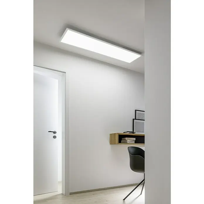Tween Light LED-Panel RC-CCT-DIM-RGB-Backlight - 36 W, L x B x H: 120 x 30 x 5 cm, Weiß, RGBW - Ein modernes Zimmer mit einer rechteckigen Deckenleuchte, einem Schreibtisch mit einem Stuhl und einer offenen Tür. Das Licht sorgt für eine helle und einladende Atmosphäre.