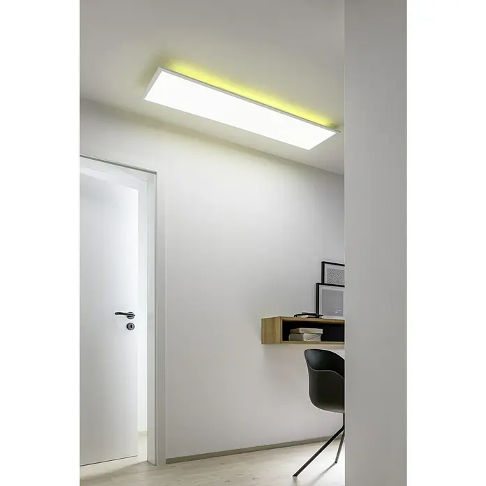 Tween Light LED-Panel RC-CCT-DIM-RGB-Backlight - 36 W, L x B x H: 120 x 30 x 5 cm, Weiß, RGBW - Deckenleuchte mit gelblichem Licht in einem minimalistischen Raum mit weißer Tür und kleinem Schreibtisch mit Stuhl.