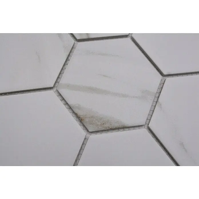 Mosaikfliese Hexagon CIM HX9 CT - 25,6 x 29,55 cm, Beige/Braun/Weiß, Matt - Nahaufnahme von sechseckigen weißen Fliesen mit Marmorierung und grauen Fugen, die ein sauberes, modernes Design zeigen.