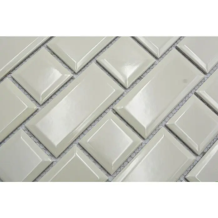 Mosaikfliese Metro Uni CG M10IM - 29,4 x 29,1 cm, Elfenbein, Glänzend - Nahaufnahme der weißen, glänzenden Keramikfliesen, die in einem Fischgrätenmuster angeordnet sind und ein elegantes Designelement darstellen.